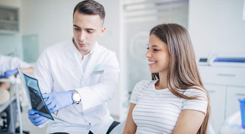Dentist showing x-ray image to a young lady